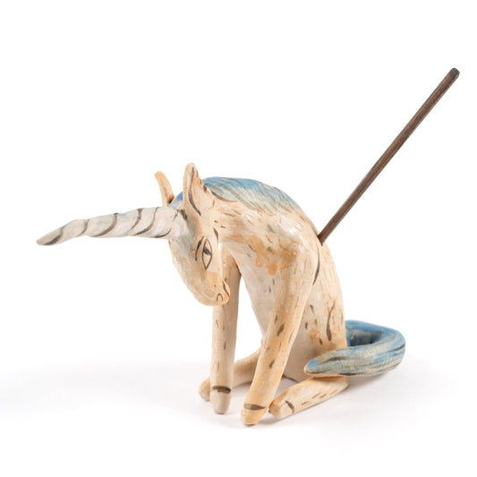A painted ceramic unicorn whistle in shades of beige with a blue mane and tail on a plain white background.