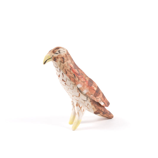 A painted ceramic vulture whistle in shades of brown with a yellow beak on a plain white background.