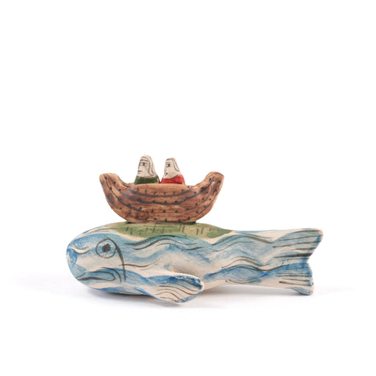 A painted ceramic whale whistle with a Noah's Ark on its back against a white background.