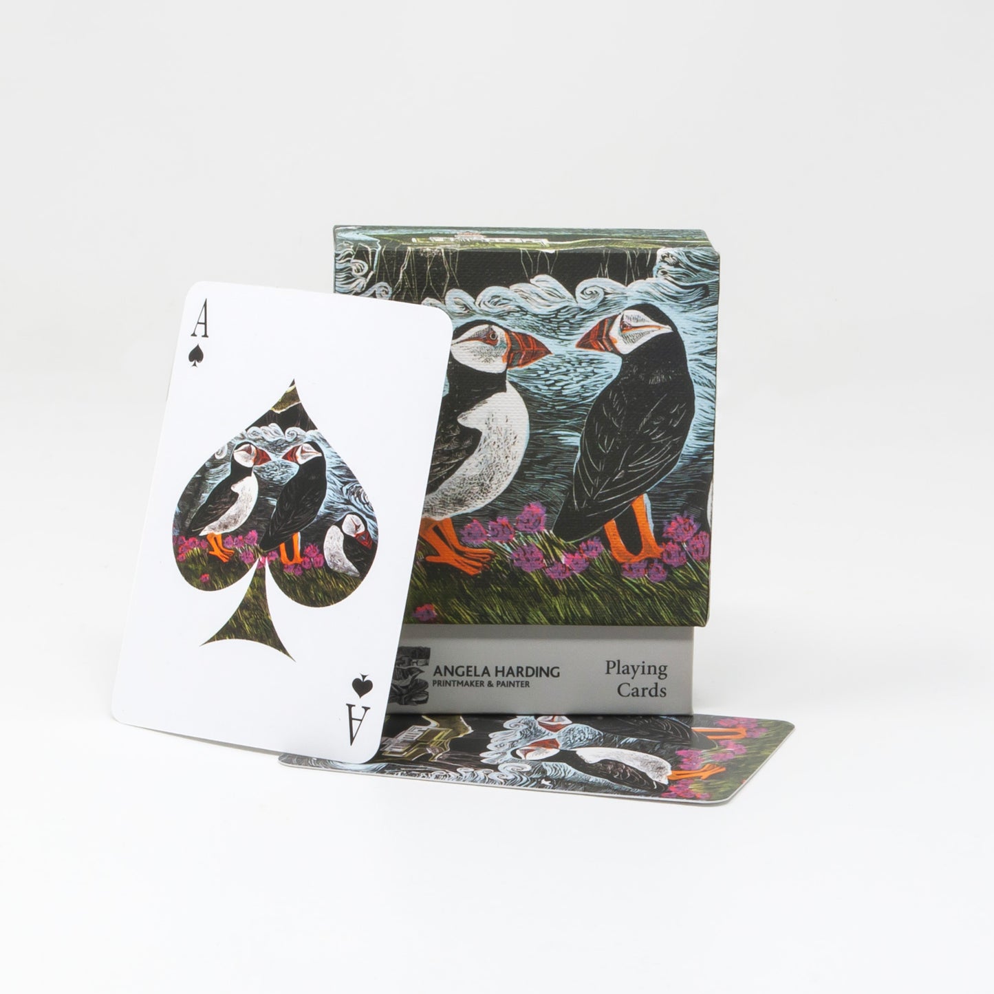 A deck of illustrated playing cards by Angela Harding, featuring puffins on the box and an Ace of Spades card displayed in front on a clean white background.