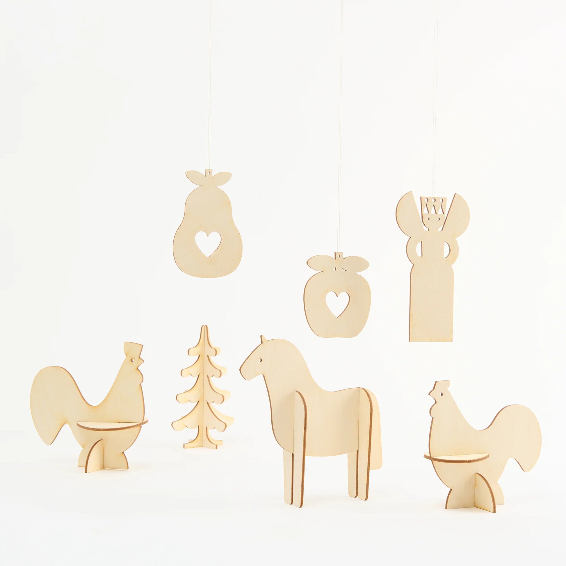 A set of seven laser cut plywood decorations on a plain white background. The shapes include two birds, two pieces of fruit, a tree, a horse and an angel.