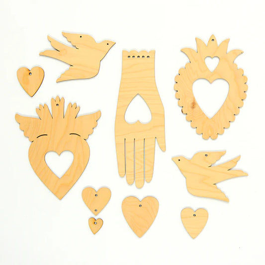 Set of laser cut plywood decorative pieces including hearts, birds, and a hand all placed on a white background