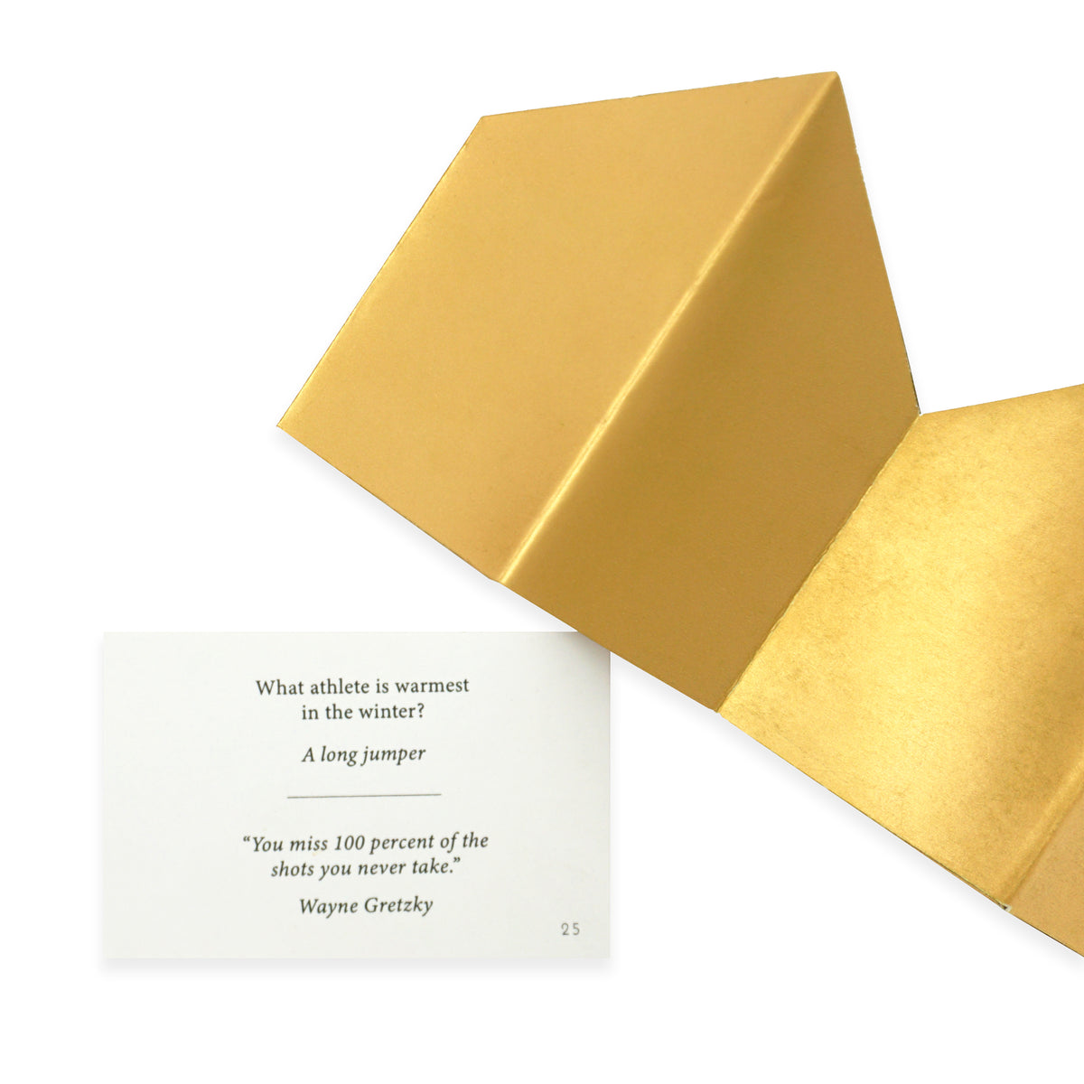 A folded gold crown is next to a piece of card with printed text on a clean white background.