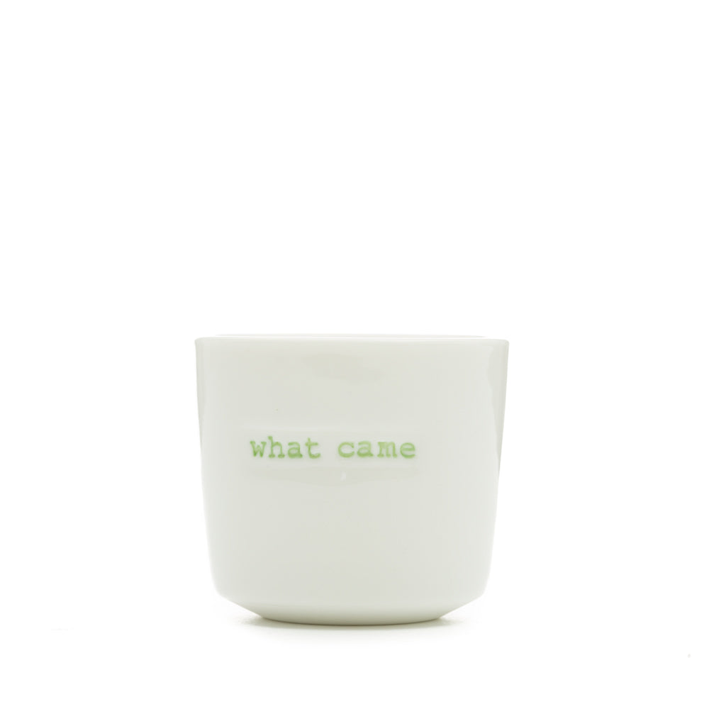 White ceramic egg cup with the words 'what came' stamped on the front
