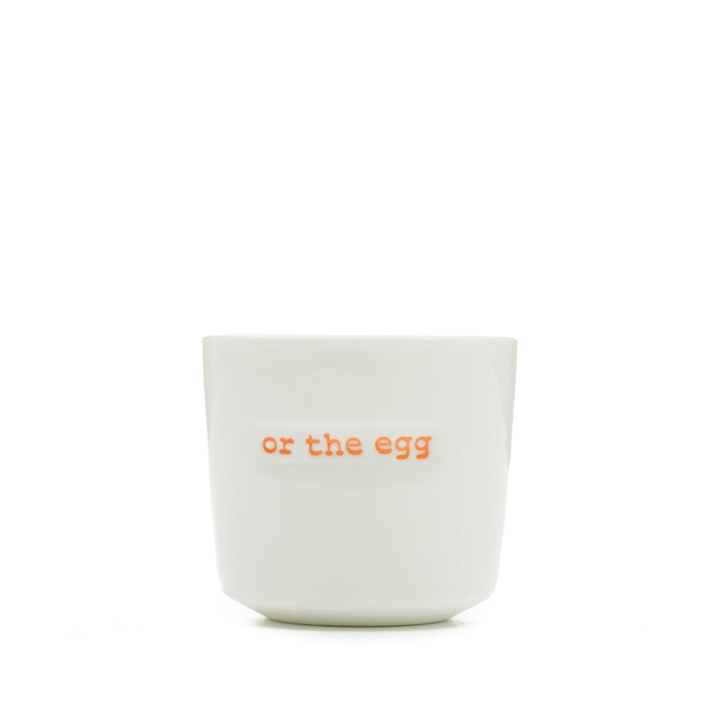 White ceramic egg cup with the words 'or the egg' stamped on the front