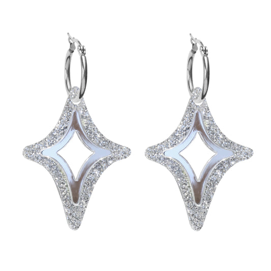 A pair of silver diamond shaped acrylic earrings on a silver hoop with silver glitter.