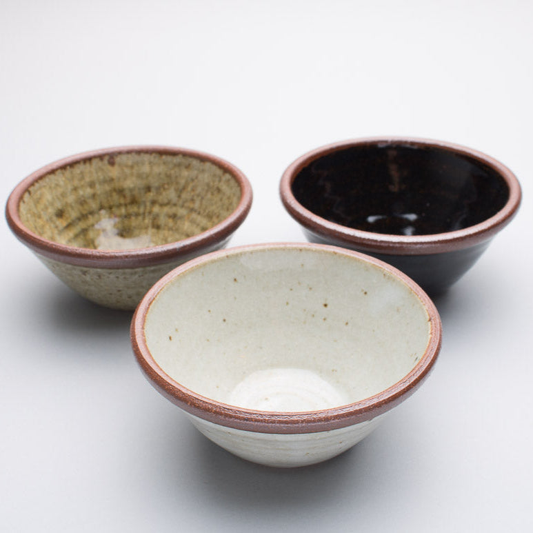 A set of three Leach Pottery bowls on a plain white background.