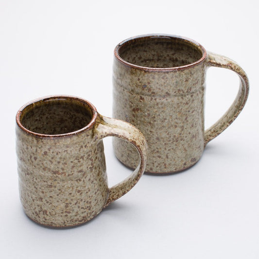 Two ceramic mugs with a speckled brown and grayish finish, one larger and one smaller, both with handles.
