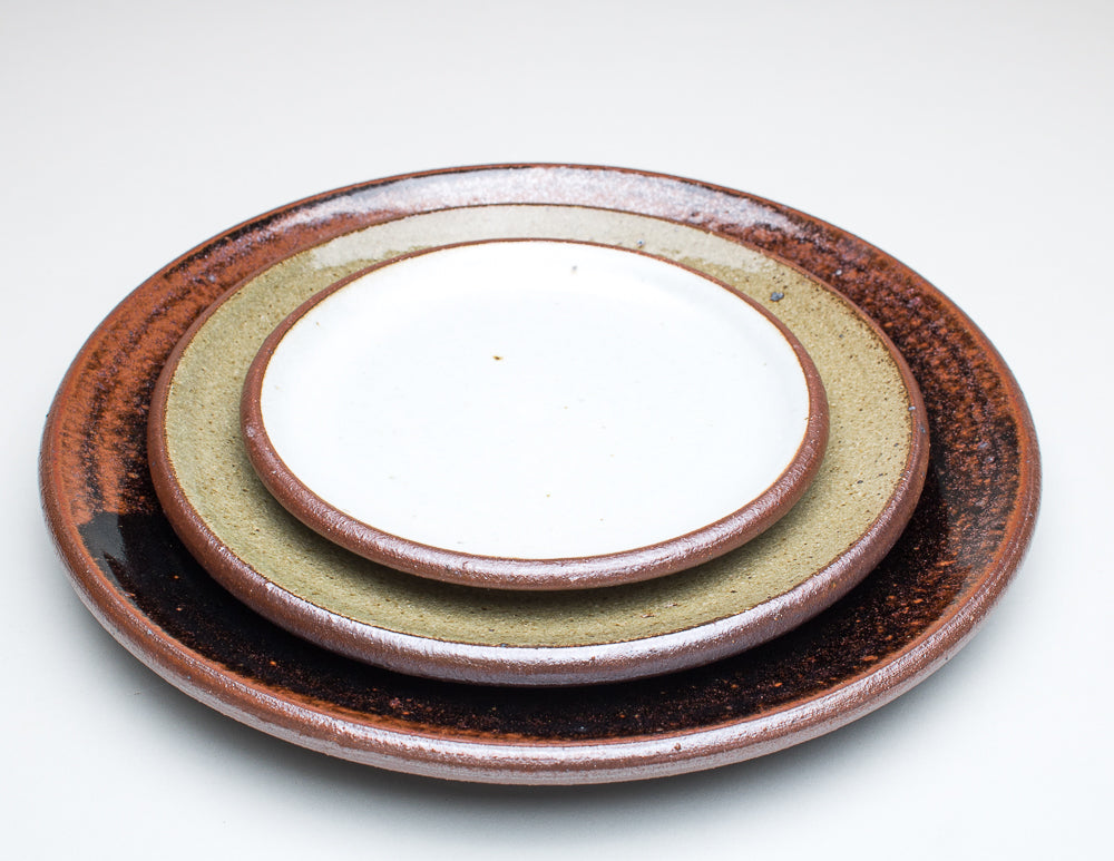 A stack of Leach Pottery plates showing the various sizes and glazes available