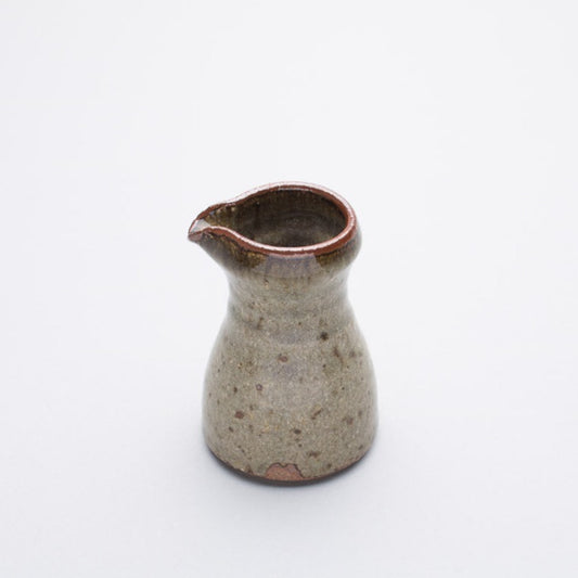 A ceramic pourer with a green to red-brown gradient ash glaze, reduction fired, from Leach Pottery.