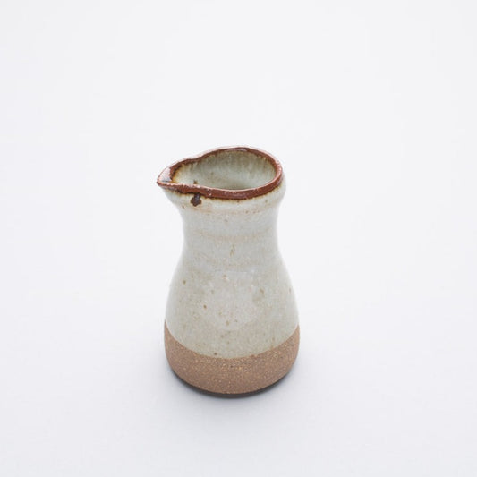 A ceramic pourer with a cream gradient ash glaze, reduction fired, from Leach Pottery.