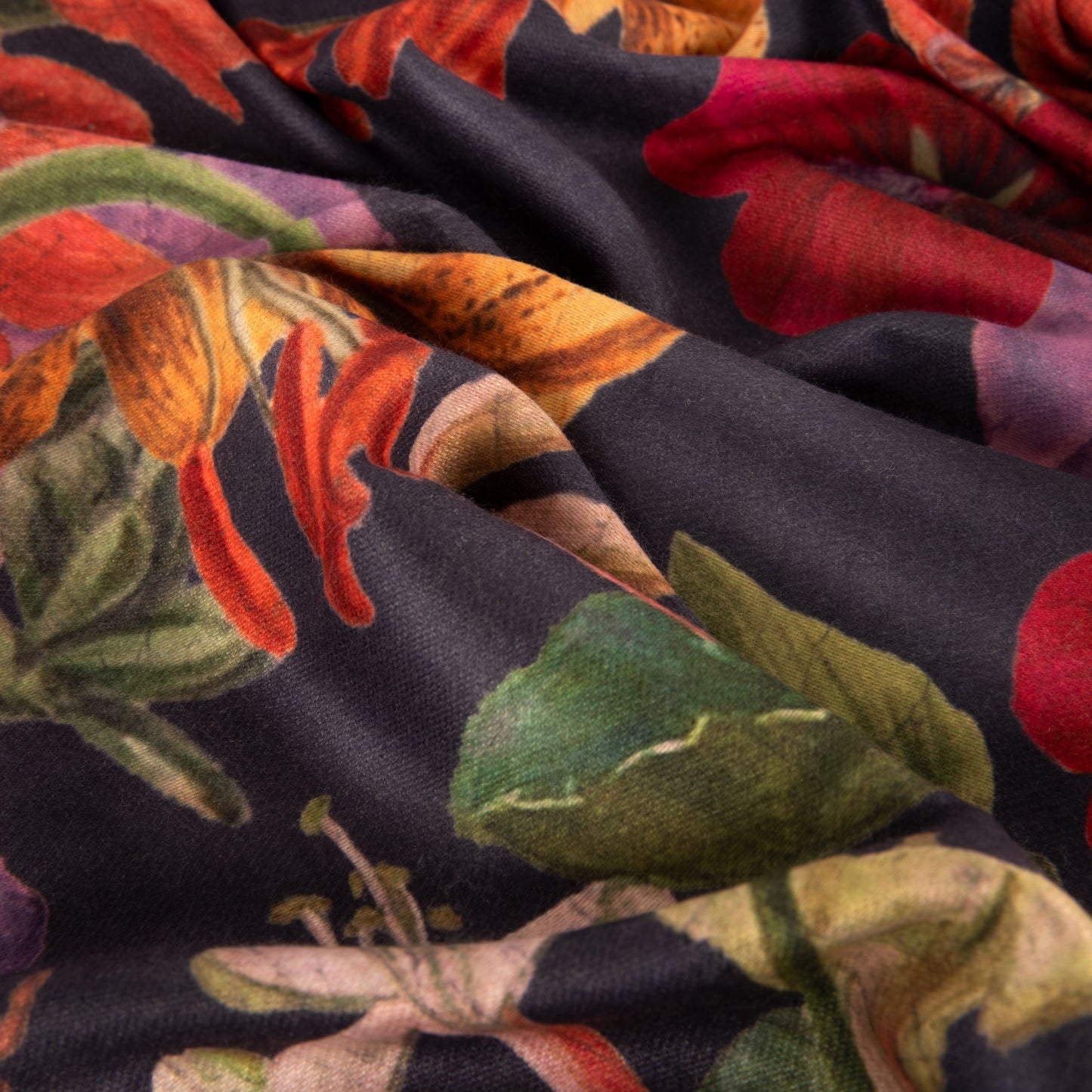 Close-up of colorful fabric with floral and leaf patterns on a dark background