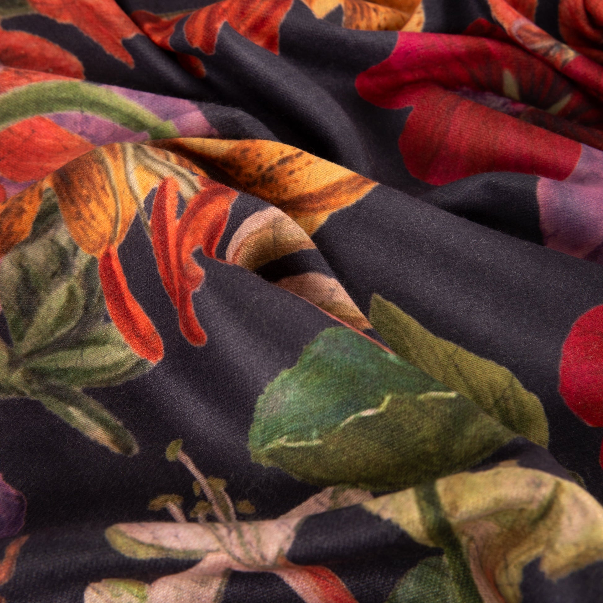 Close-up of colorful fabric with floral and leaf patterns on a dark background