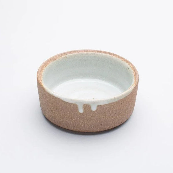 Ceramic bowl with a beige exterior and white interior on a white background