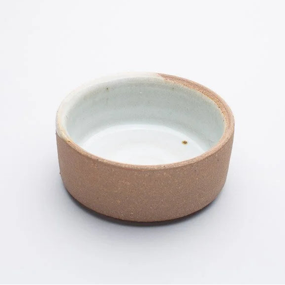 Ceramic bowl with a beige exterior and white interior on a white background
