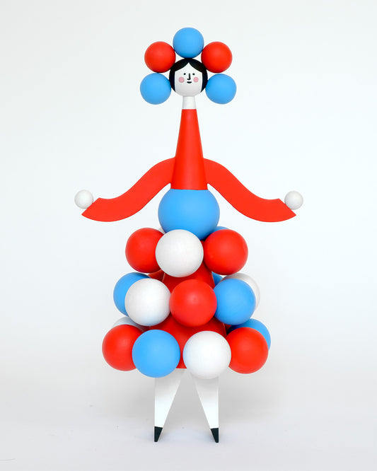 Colourful sculpture of a figure made from red, blue, and white spheres on a red body with white legs on a plain white background.