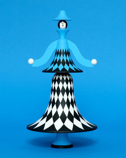 A colourful sculpture with a white, black and blue diamond patterned curved body with blue legs and a blue top hat on a plain blue background.