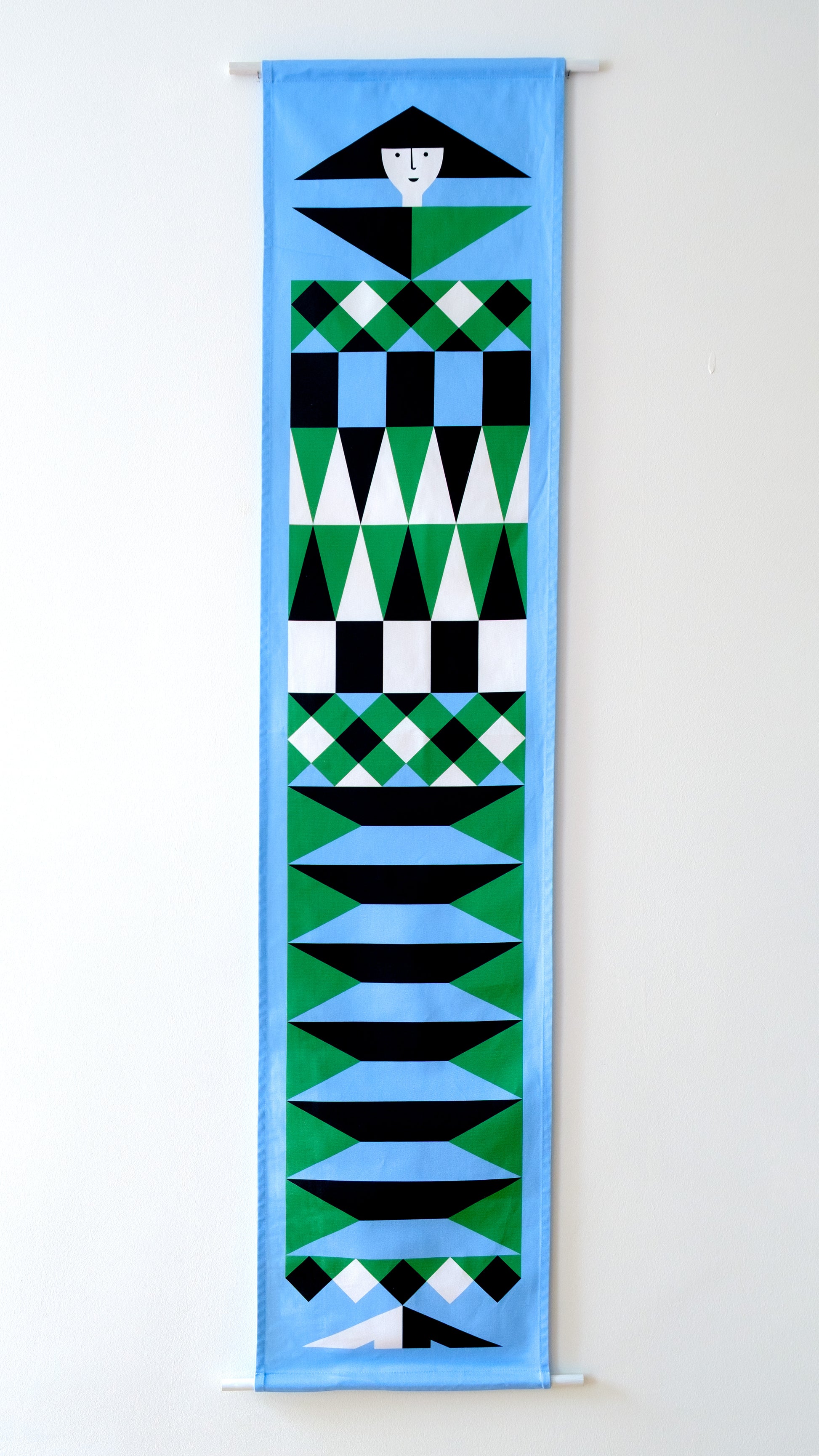 A fabric banner featuring a blue and green geometric figure with black and white accents. 