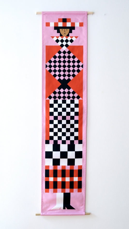 A fabric banner featuring a pink and red geometric figure with black and white accents. 