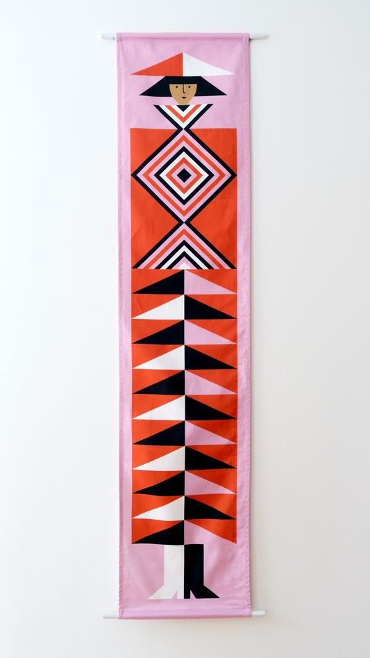 A fabric banner featuring a red and pink geometric figure with black and white accents. 