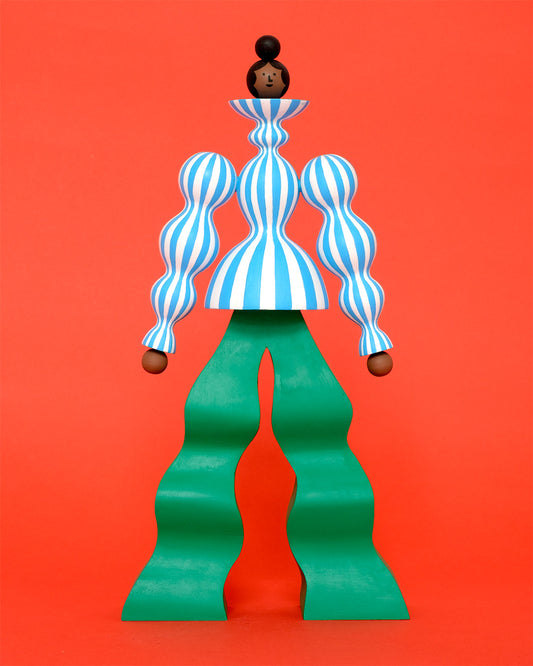 A colourful sculpture with a blue and white stripey body with wavy green trousers on a plain orange background.