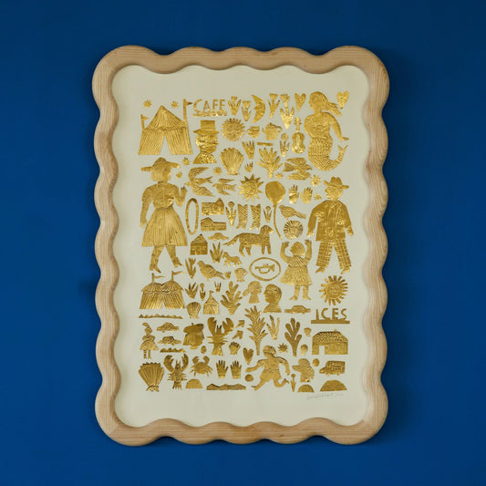 A decorative tray featuring a variety of gold illustrations on a cream background. The designs include people, animals, plants, and various symbols, all arranged in a grid pattern. The tray has a scalloped wooden frame and is set against a blue wall.