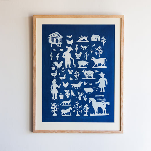 A framed artwork featuring a blue background with white silhouettes of farm animals, a barn, trees, and two figures. The design includes cows, chickens, pigs, and other farm elements, creating a whimsical rural scene.