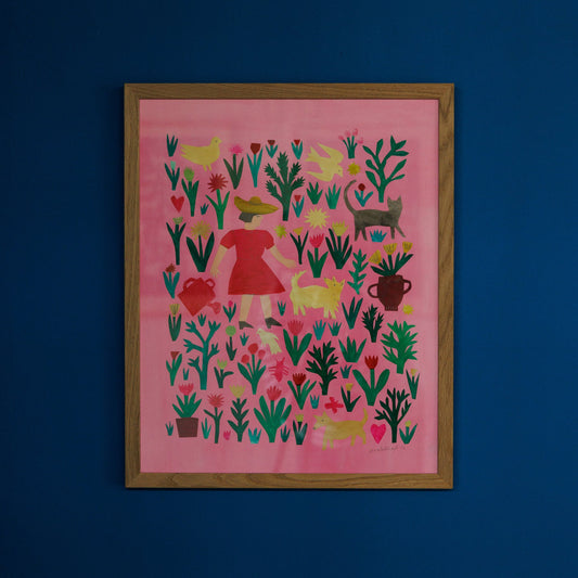 A framed artwork featuring a vibrant pink background adorned with various plants, animals, and a red dress. The design includes stylised shapes of birds, hearts, and pots, all set against a deep blue wall.
