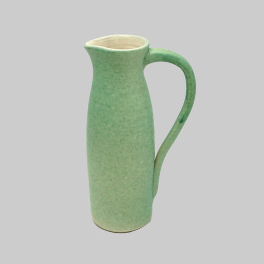 Green ceramic pitcher on a white background
