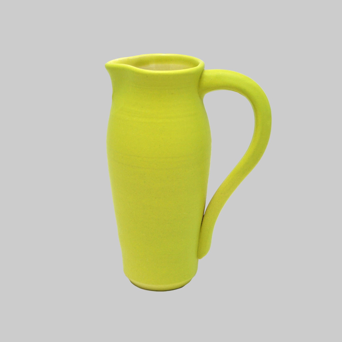 Green ceramic pitcher on a white background