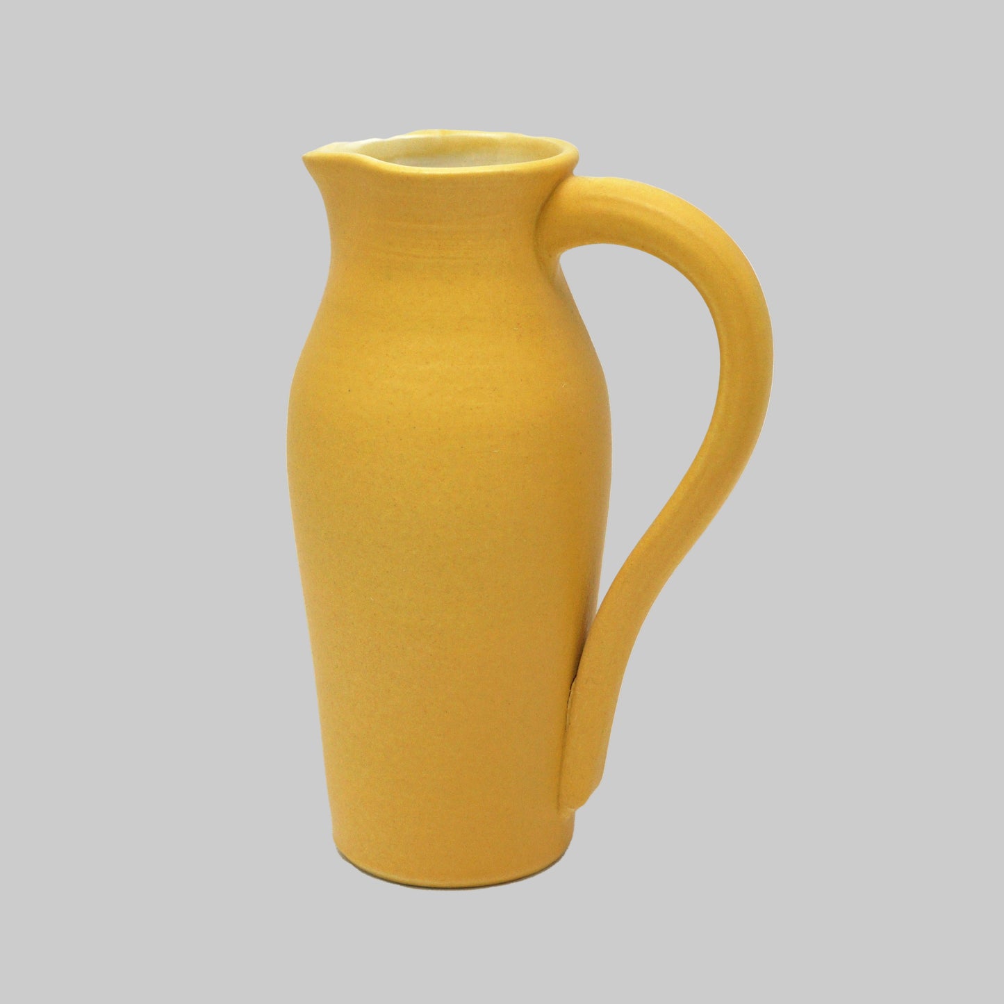 Yellow ceramic pitcher on a white background