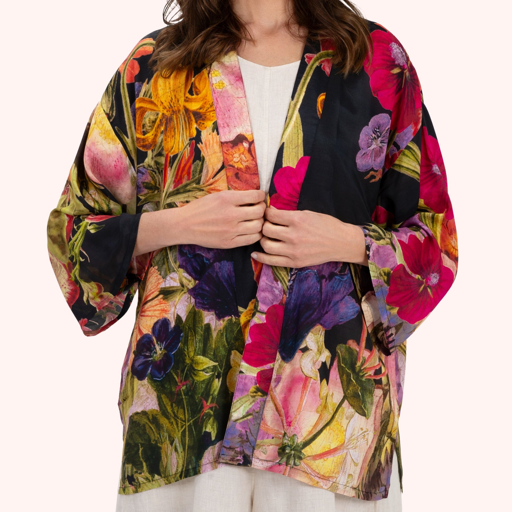 Woman wearing a colorful floral kimono-style jacket on a white background