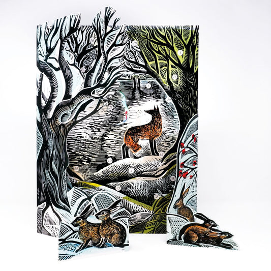 A decorative advent calendar featuring a woodland scene with a fox and several hares, shown standing upright with matching cutout pieces placed in front on a white background.