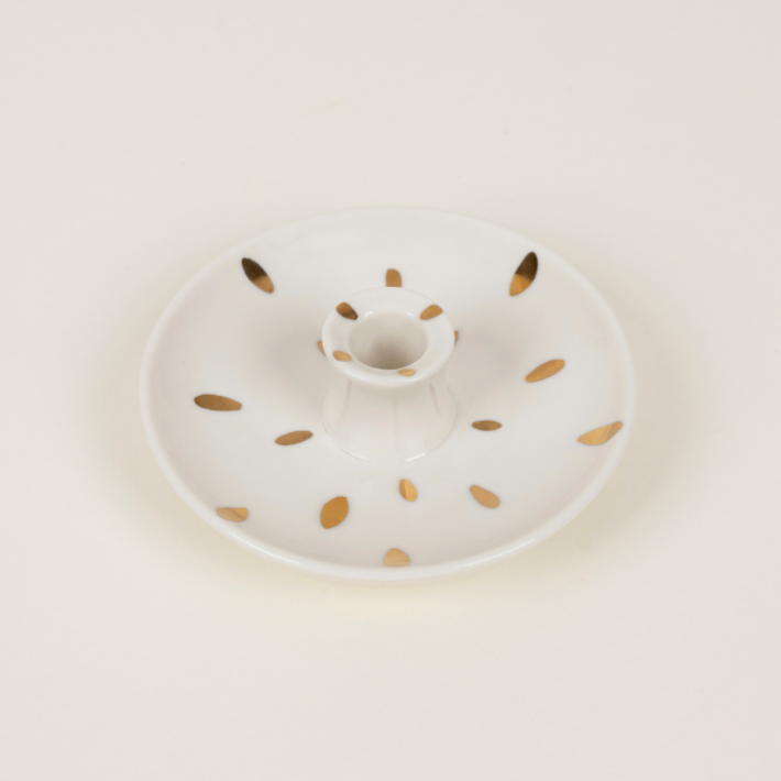 White ceramic plate with gold speckles on a light beige background