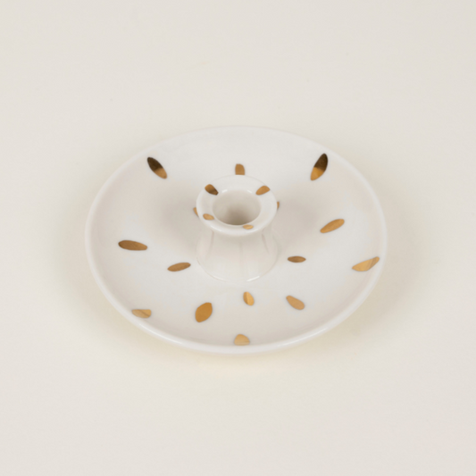 White ceramic plate with gold speckles on a light beige background