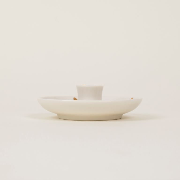 White ceramic dish with a small white container on a light beige background