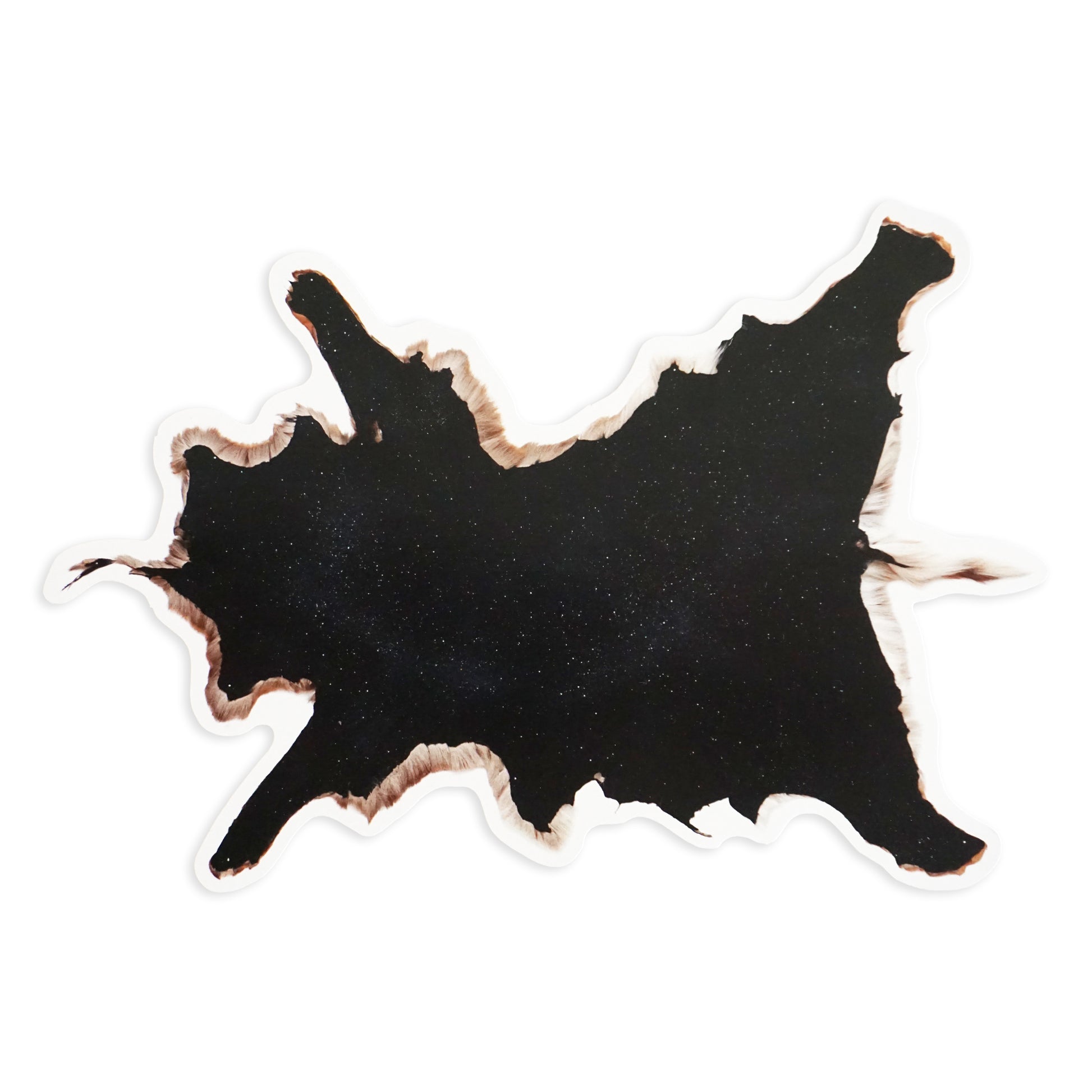 Abstract black shape with irregular, jagged edges resembling a cow hide. The edges are slightly burnt or charred, creating a contrast against the white background. The texture appears smooth and glossy.