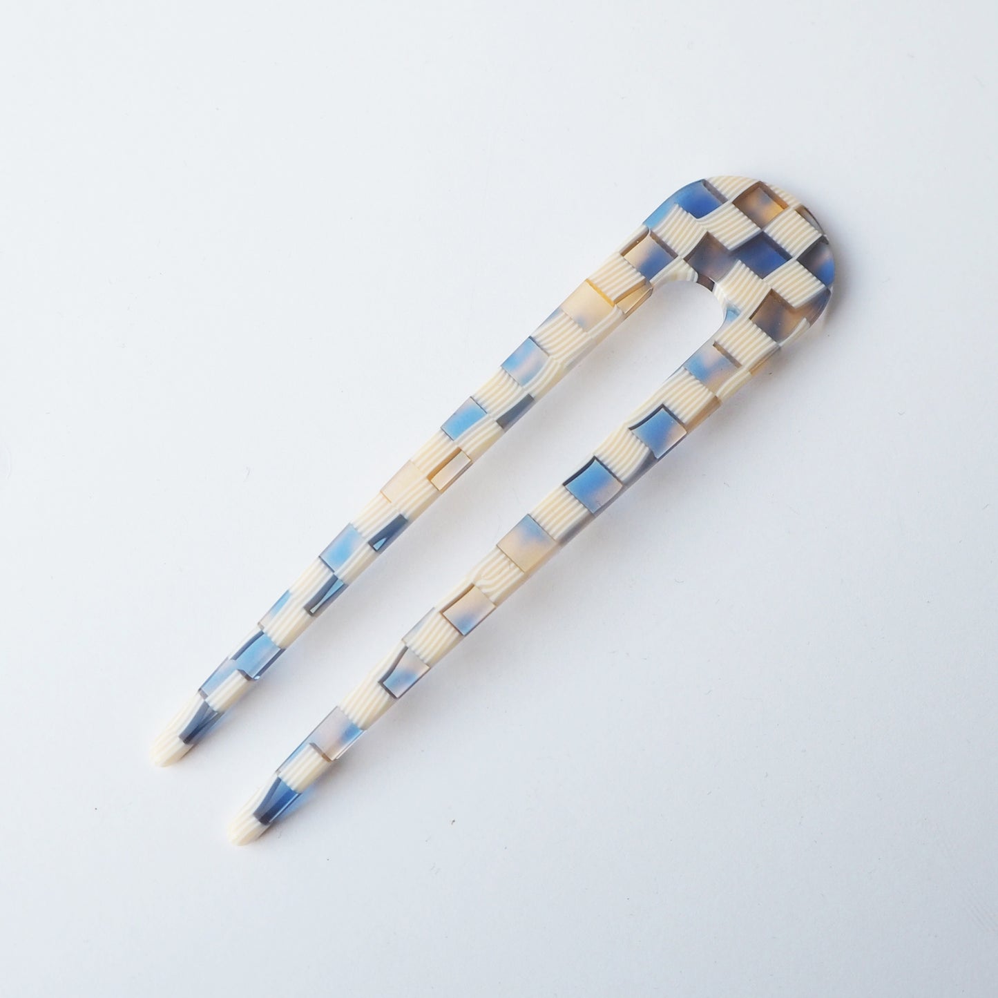 Checkered hair clip in blue and beige on a white background