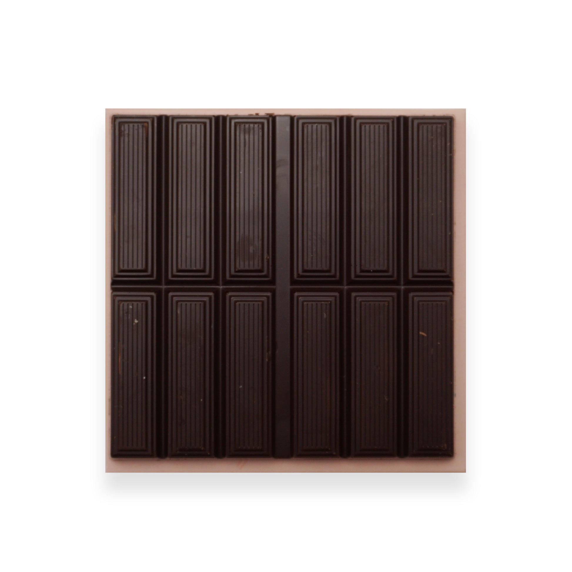 An open bar of dark chocolate sitting on an orange cardboard packet.