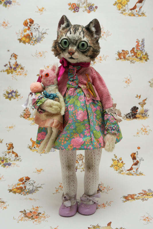 A whimsical cat doll dressed in a floral dress, pink cardigan, and purple shoes holds a smaller plush toys. The background features playful animal illustrations, adding a charming, vintage feel to the scene.