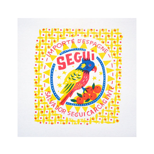 A vibrant graphic design featuring a colourful parrot and oranges, framed by a decorative border. The text reads "Importe d'Espagne" and "Salvador Segui Carcagente," highlighting a Spanish import theme.