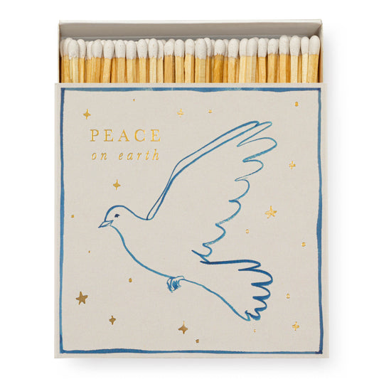 A box of matches with a 'Peace on Earth' message and a white dove illustration, surrounded by gold text and stars.