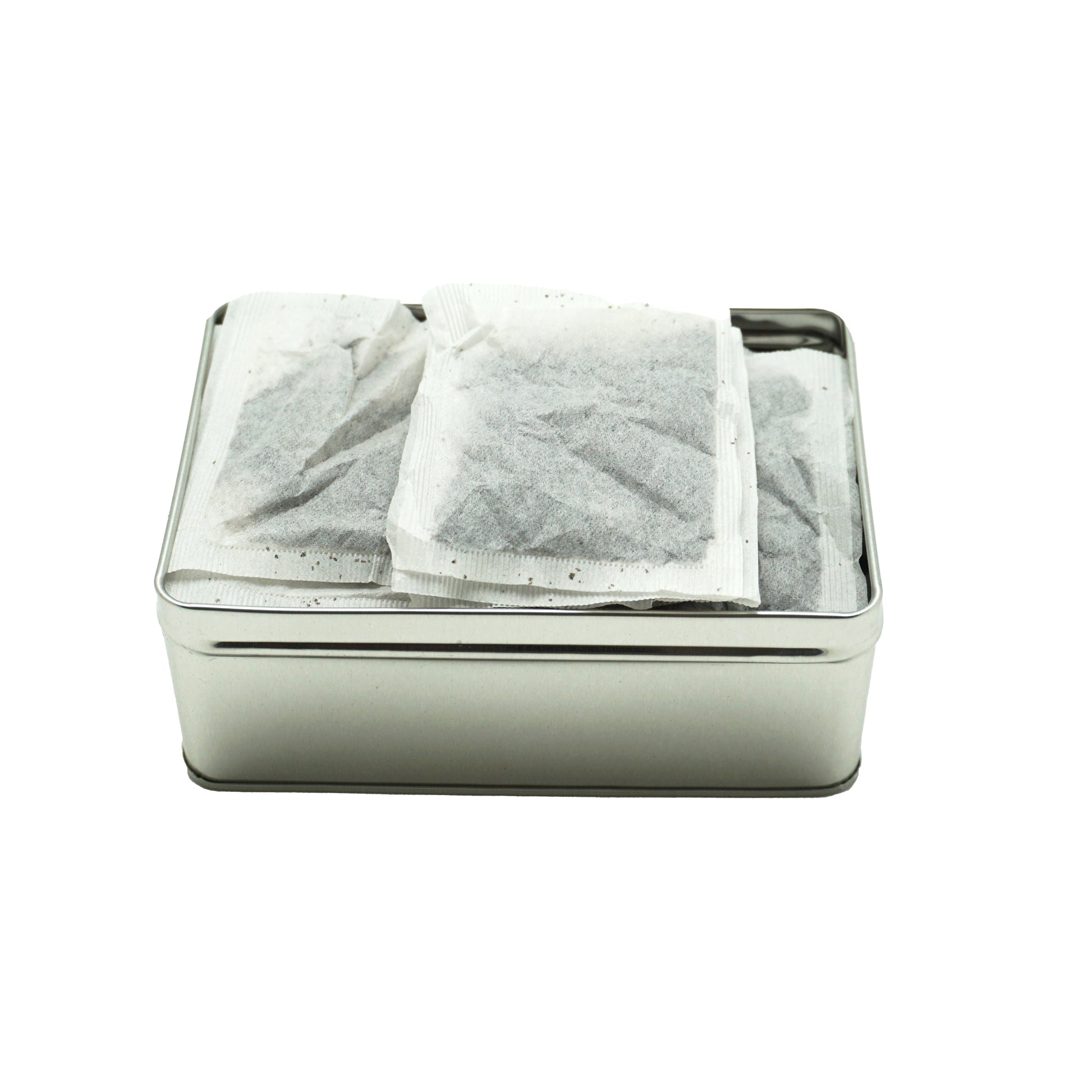 An open metal tin showing rectangular tea bags inside.