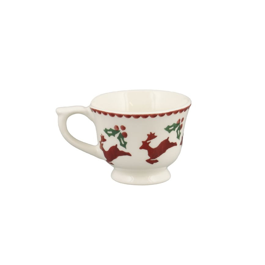 A white ceramic teacup decorated with red Christmas-themed illustrations of reindeer and holly, set against a plain white background.