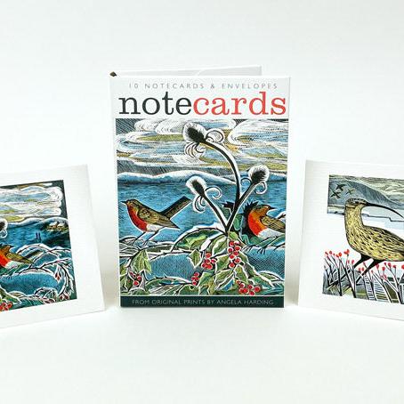 A set of notecards with matching envelopes, featuring two original prints of robins and teasels in a wintry landscape by print maker Angela Harding.