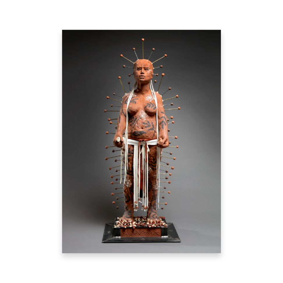 A life-sized sculpture of a figure covered in intricate body art and clay, standing confidently. The figure is adorned with numerous pins radiating from the head, and white ribbons hang from the waist, set against a dark background.