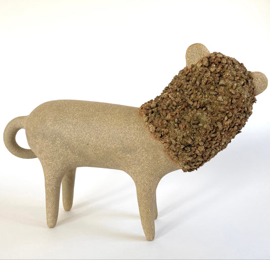 Ceramic lion sculpture with textured fur on a white background