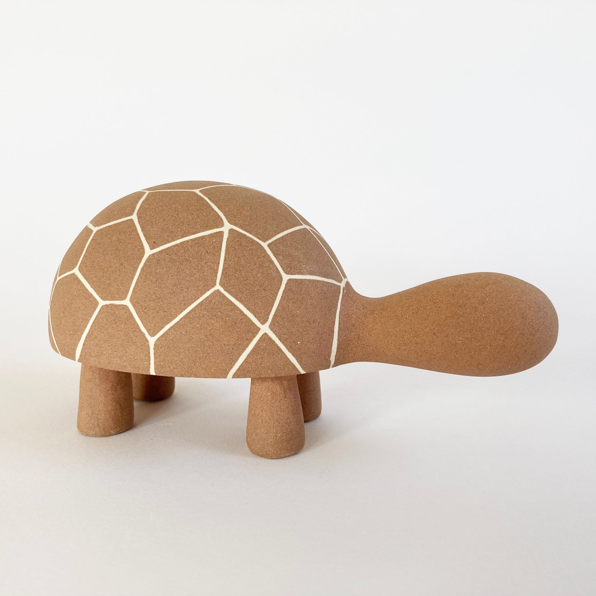 Ceramic tortoise with geometric pattern on a white background