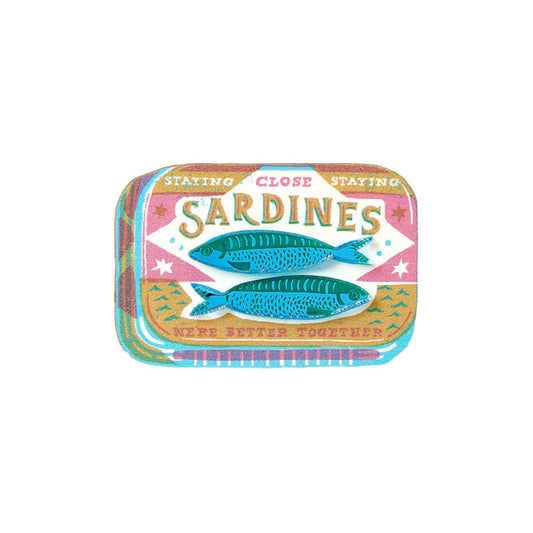 Sardine can-shaped brooch with colourful design on a white background.