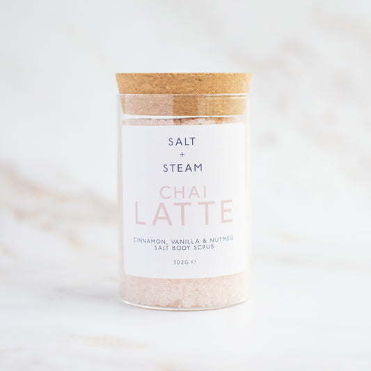 Jar of 'Chai Latte' salt body scrub with 'Salt + Steam' branding on a light background